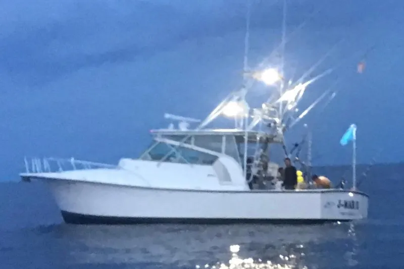 Slide: The Image of 2007 Henriques 42 Express boat illuminated on the ocean at dusk. - 84