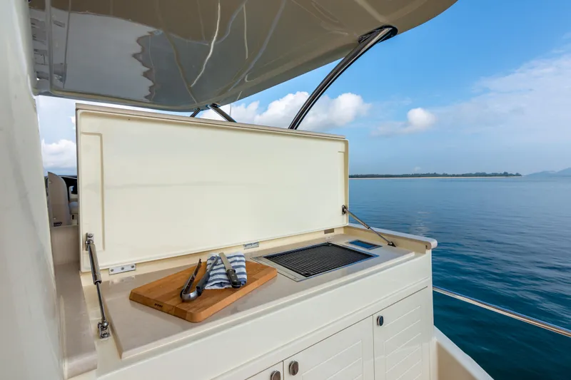 Slide: The Image of Outdoor kitchen on 2021 Palm Beach Motor Yachts PB65, featuring a grill and cutting board. - 10