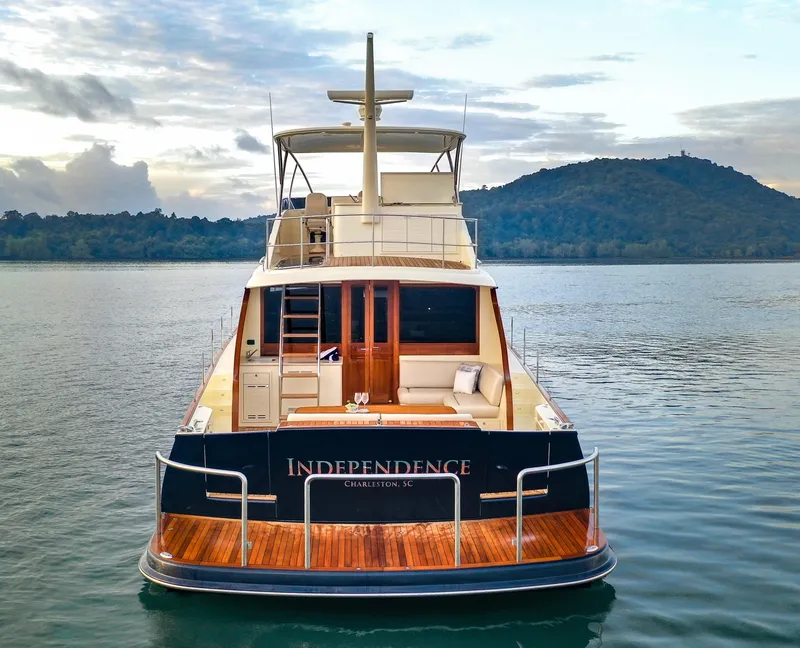 Slide: The Image of 2021 Palm Beach Motor Yachts PB65 on serene water with scenic backdrop. - 29