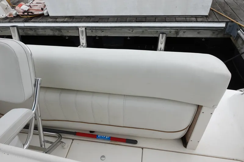 Slide: The Image of 1997 Sea Ray 270 Sundancer boat interior with white seating and dock view. - 10