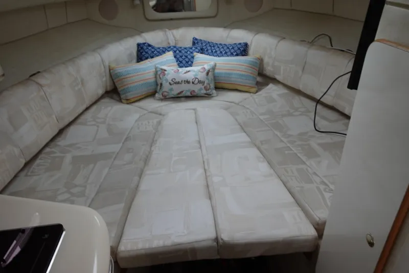 Slide: The Image of 1997 Sea Ray 270 Sundancer cabin with cozy bedding and decorative pillows. - 11