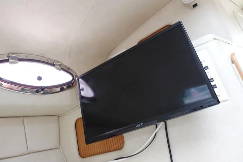 Slide: The Image of Interior of 1997 Sea Ray 270 Sundancer with mounted Vizio TV and porthole window. - 12