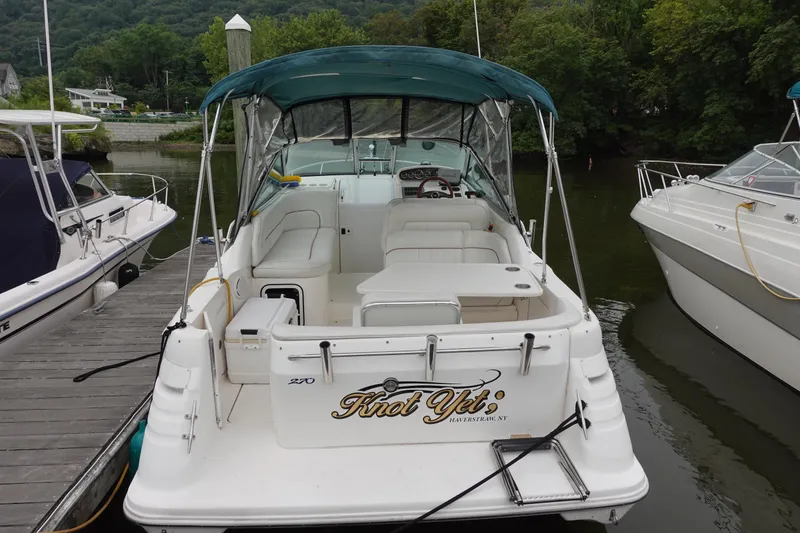 Slide: The Image of 1997 Sea Ray 270 Sundancer docked, featuring spacious seating and canopy, labeled "Knot Yet." - 2