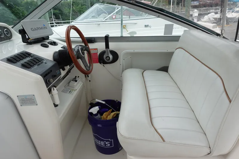 Slide: The Image of Interior of 1997 Sea Ray 270 Sundancer boat with steering wheel and white seating. - 4
