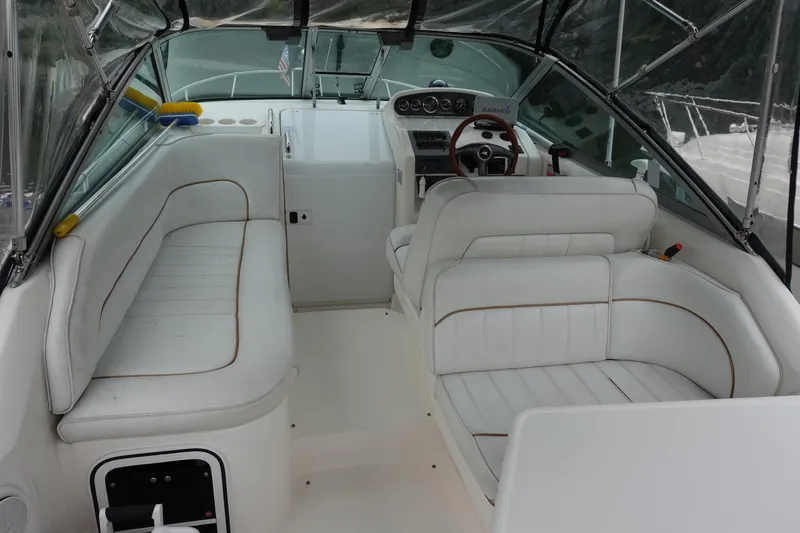 Slide: The Image of 1997 Sea Ray 270 Sundancer boat interior with white seating and steering console. - 7