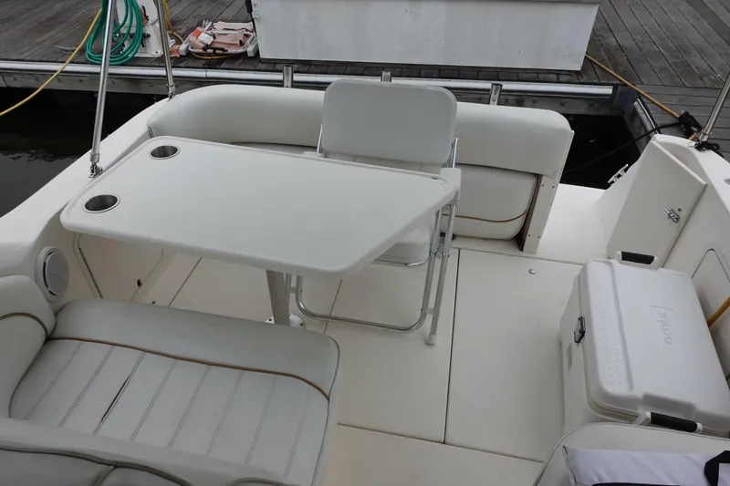 Slide: The Image of 1997 Sea Ray 270 Sundancer boat interior with seating, table, and cooler on deck. - 9