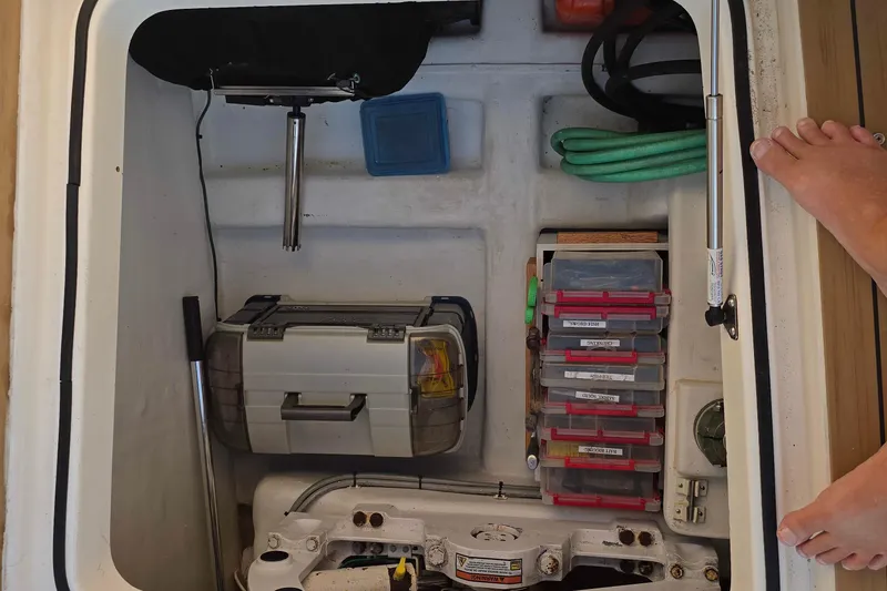 Slide: The Image of Storage compartment on a 2003 Riviera 48 Flybridge, featuring tools and organized boxes. - 11