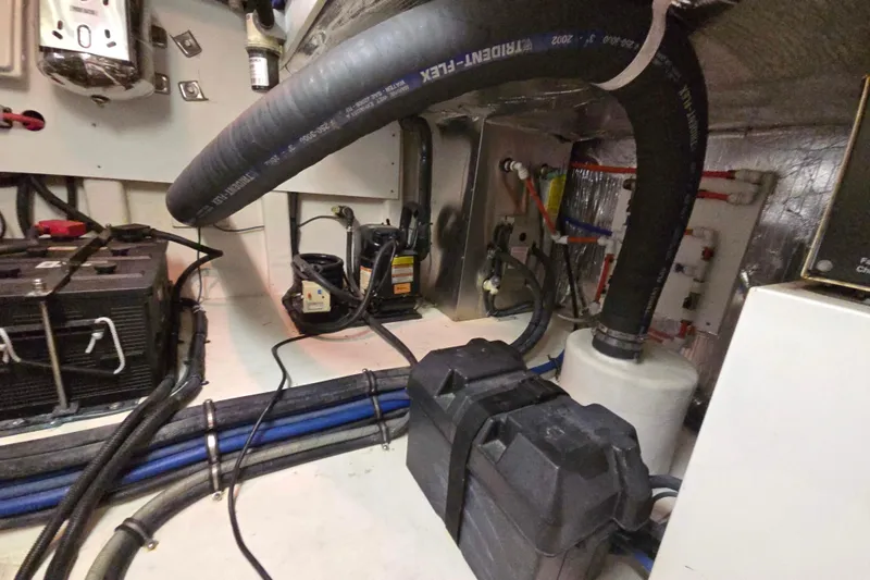 Slide: The Image of Engine room of 2003 Riviera 48 Flybridge with hoses, wiring, and equipment. - 23