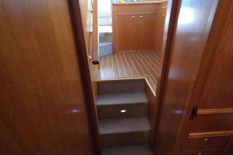 Slide: The Image of Interior view of 2003 Riviera 48 Flybridge yacht with wooden cabinetry and carpeted steps. - 35