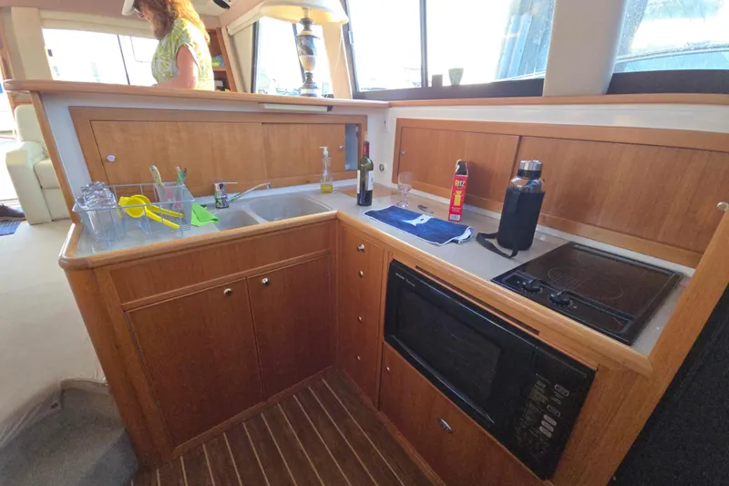 Slide: The Image of 2003 Riviera 48 Flybridge yacht kitchen with wooden cabinetry and modern appliances. - 37