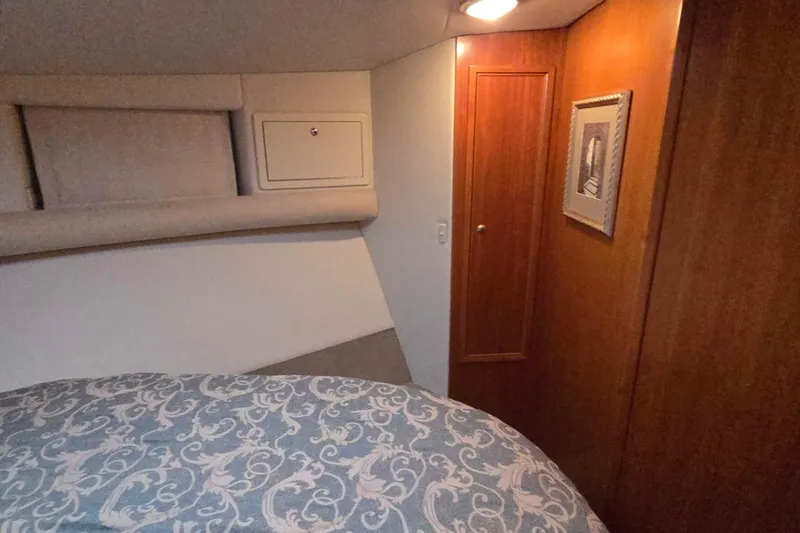 Slide: The Image of Cozy bedroom interior of 2003 Riviera 48 Flybridge yacht with elegant wood paneling. - 41