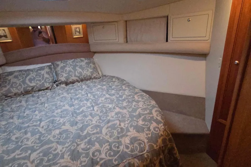 Slide: The Image of Interior of 2003 Riviera 48 Flybridge yacht with elegant bedding and wood accents. - 43