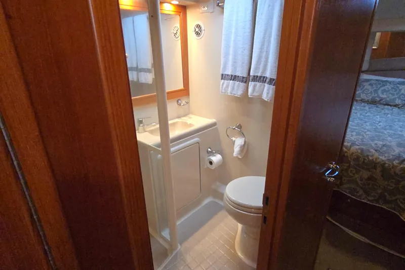 Slide: The Image of Bathroom interior of 2003 Riviera 48 Flybridge yacht, featuring sink, toilet, and mirror. - 46