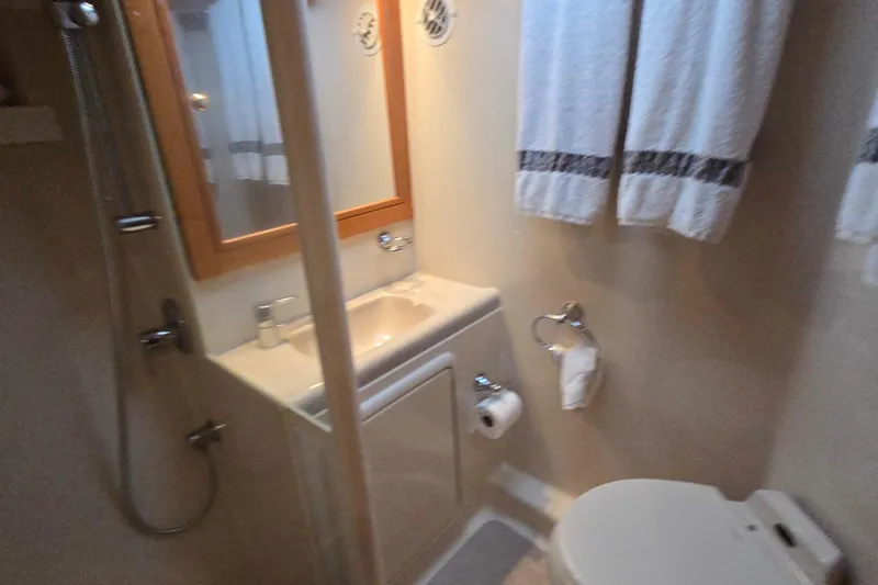 Slide: The Image of Bathroom interior of 2003 Riviera 48 Flybridge yacht, featuring sink, shower, and toilet. - 48