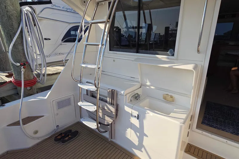 Slide: The Image of 2003 Riviera 48 Flybridge yacht with ladder and outdoor sink area. - 5