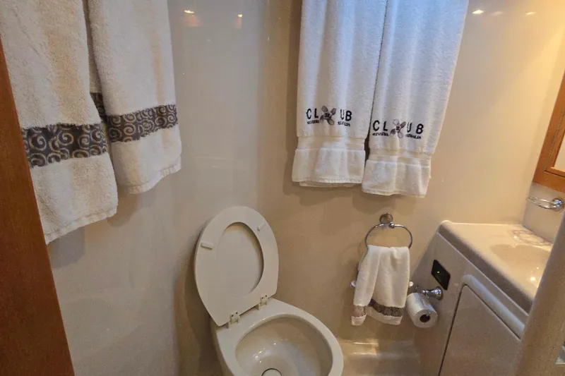 Slide: The Image of Bathroom interior of 2003 Riviera 48 Flybridge yacht with towels and toilet. - 52