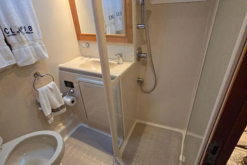 Slide: The Image of Compact bathroom in 2003 Riviera 48 Flybridge yacht with shower and sink. - 53