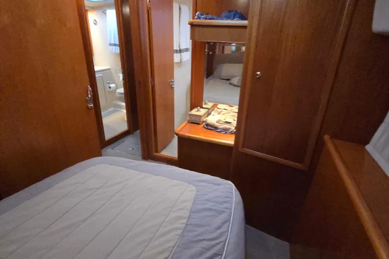 Slide: The Image of 2003 Riviera 48 Flybridge cabin interior with wooden finish and cozy bedding. - 55