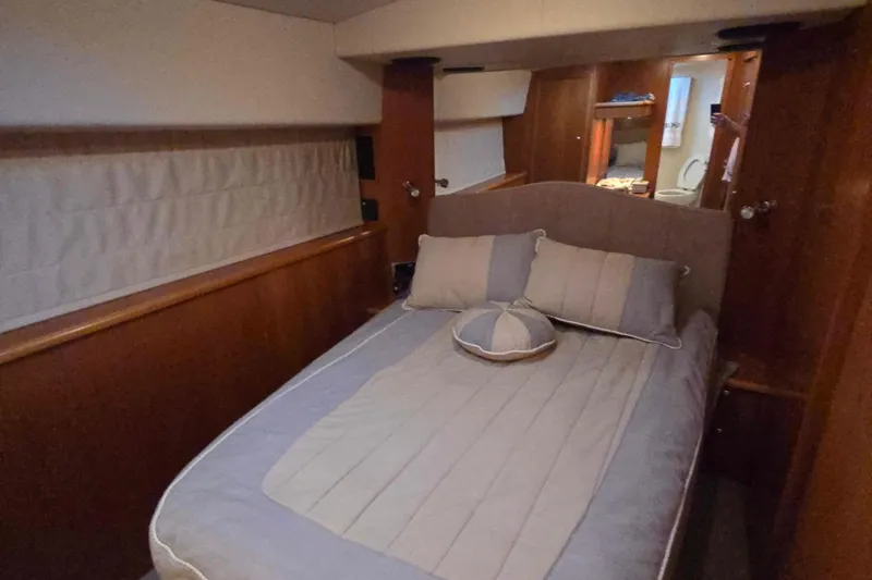 Slide: The Image of Cozy bedroom in 2003 Riviera 48 Flybridge yacht with elegant wood paneling. - 56