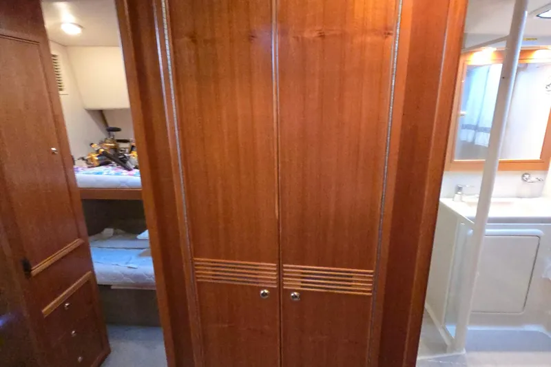 Slide: The Image of Interior of 2003 Riviera 48 Flybridge yacht with wooden cabinetry and bathroom view. - 58