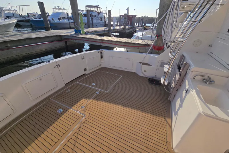 Slide: The Image of 2003 Riviera 48 Flybridge yacht deck with teak flooring at marina. - 6