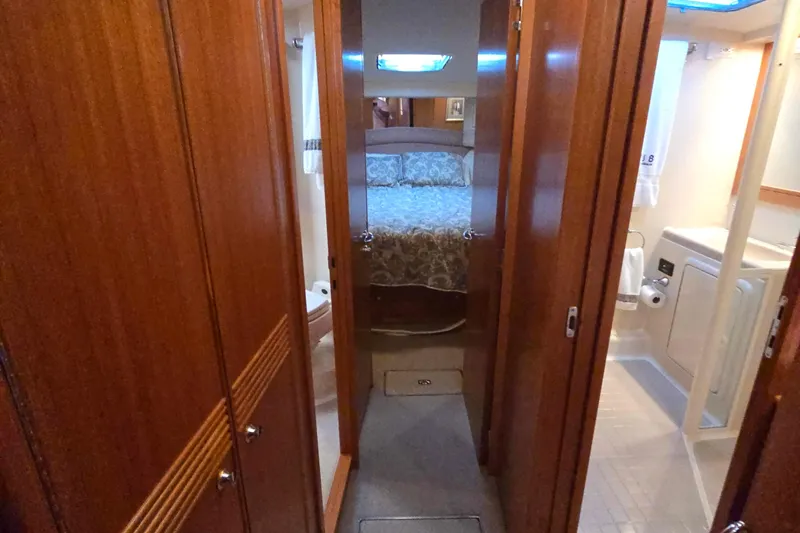 Slide: The Image of Interior of 2003 Riviera 48 Flybridge yacht, featuring cozy bedroom and bathroom. - 60