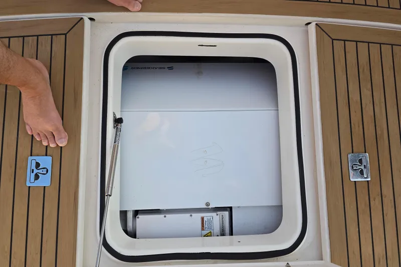 Slide: The Image of Open hatch on 2003 Riviera 48 Flybridge boat deck, revealing storage compartment. - 7