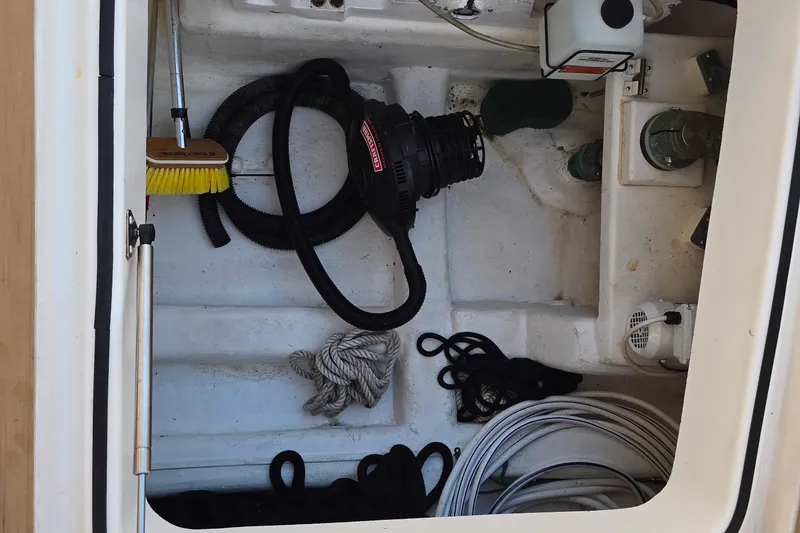 Slide: The Image of Storage compartment on 2003 Riviera 48 Flybridge with cleaning tools and ropes. - 8