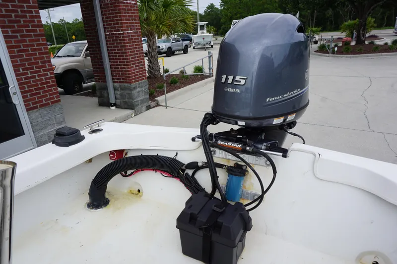Slide: The Image of 2005 Twin Vee 19 boat with Yamaha 115 four-stroke outboard motor in a parking area. - 13