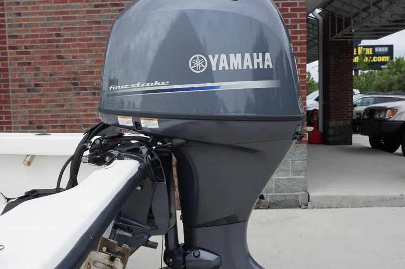 Slide: The Image of Yamaha four-stroke outboard motor on a 2005 Twin Vee 19 boat, parked near a brick wall. - 15