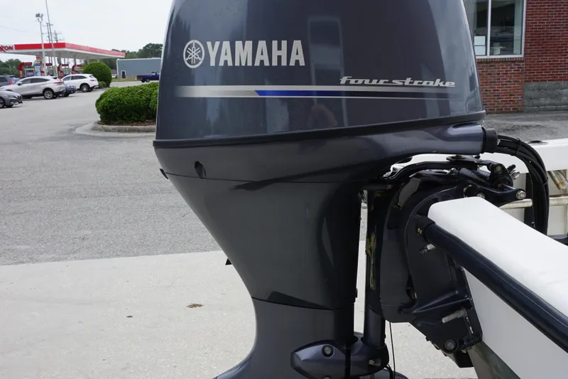 Slide: The Image of Yamaha four-stroke outboard motor on a 2005 Twin Vee 19 boat, parked near a gas station. - 16