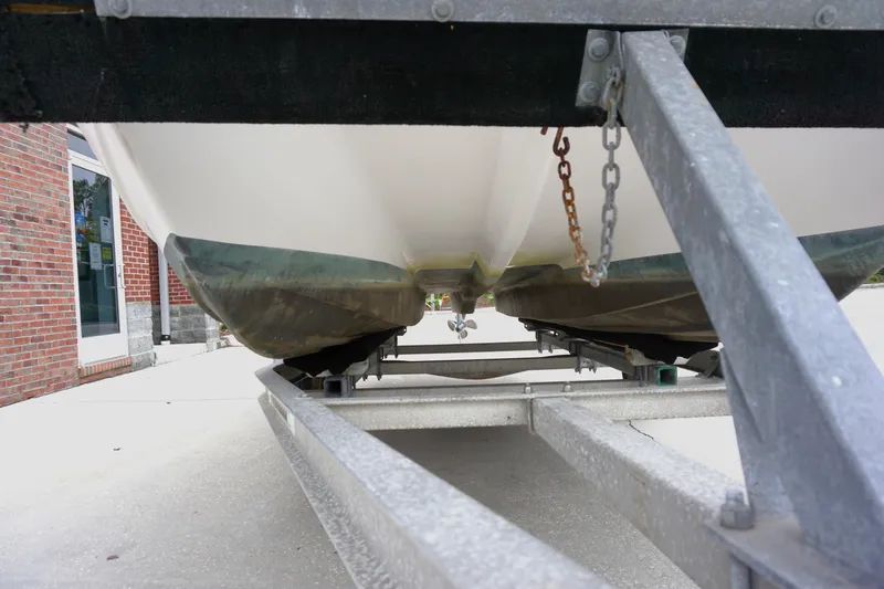Slide: The Image of 2005 Twin Vee 19 boat on trailer, viewed from below, near brick building. - 17