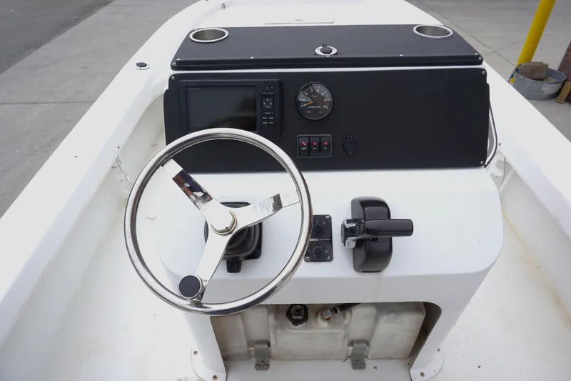 Slide: The Image of Steering console of a 2005 Twin Vee 19 boat with controls and gauges. - 7