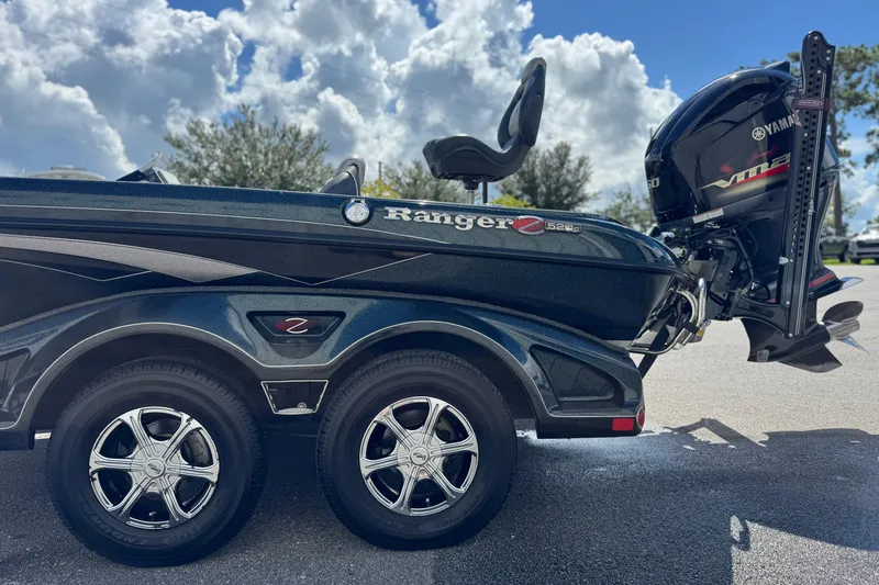 Slide: The Image of 2014 Ranger 520C boat with Yamaha engine, parked under a cloudy sky. - 17