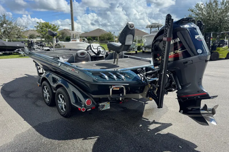 Slide: The Image of 2014 Ranger 520C boat with Yamaha outboard motor, parked outdoors under a cloudy sky. - 21