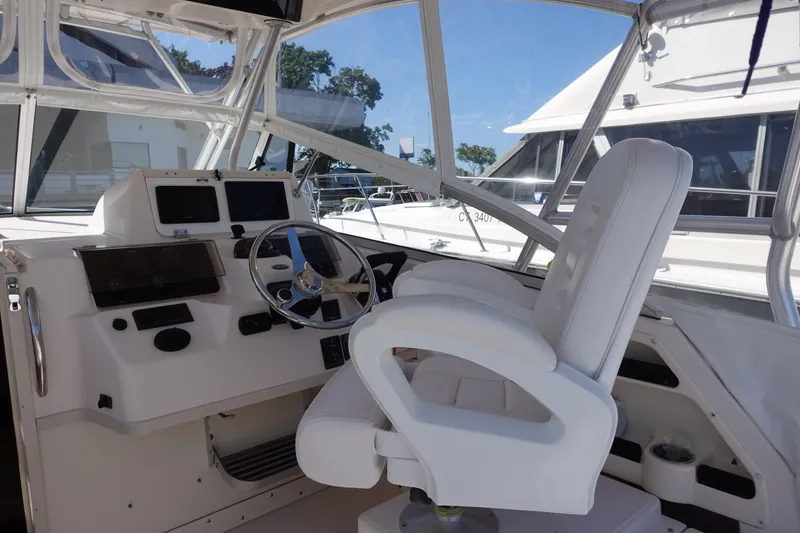 Slide: The Image of 2002 Grady White 300 Marlin boat cockpit with steering wheel and white captain's chair. - 11