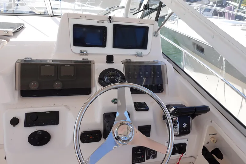Slide: The Image of 2002 Grady White 300 Marlin boat helm with steering wheel and navigation controls. - 13