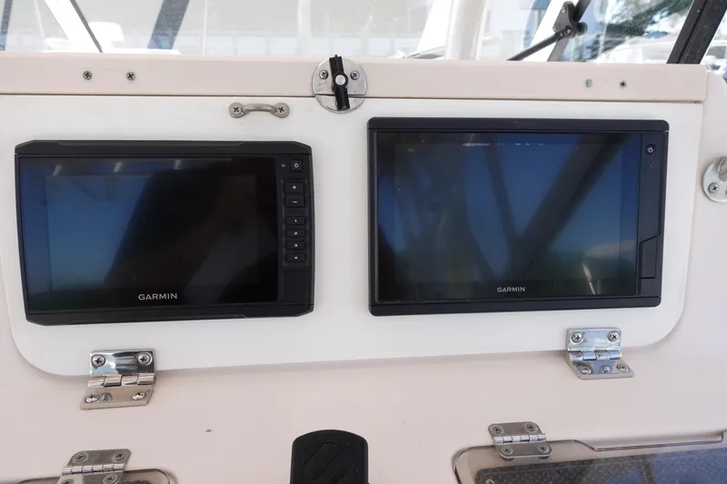 Slide: The Image of Garmin navigation screens on a 2002 Grady White 300 Marlin boat dashboard. - 14