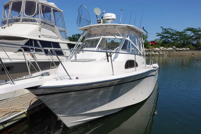 Slide: The Image of 2002 Grady-White Marlin 300 boat docked in a marina, clear blue sky. - 2
