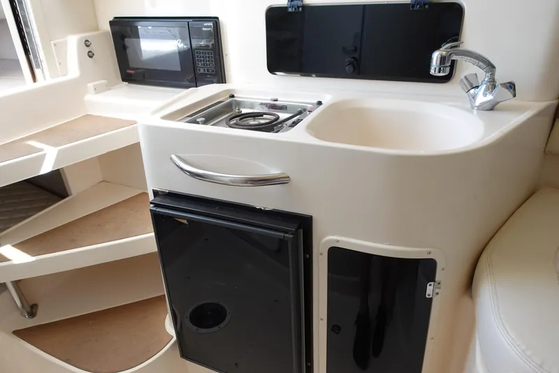 Slide: The Image of 2002 Grady White 300 Marlin boat interior with kitchenette, sink, and microwave. - 23