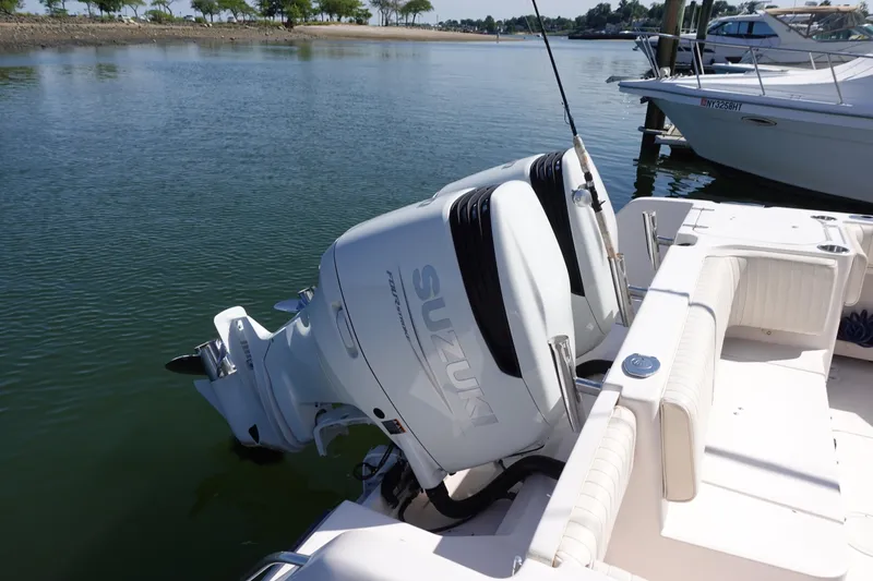 Slide: The Image of 2002 Grady White 300 Marlin boat with Suzuki outboard engines on calm water. - 4