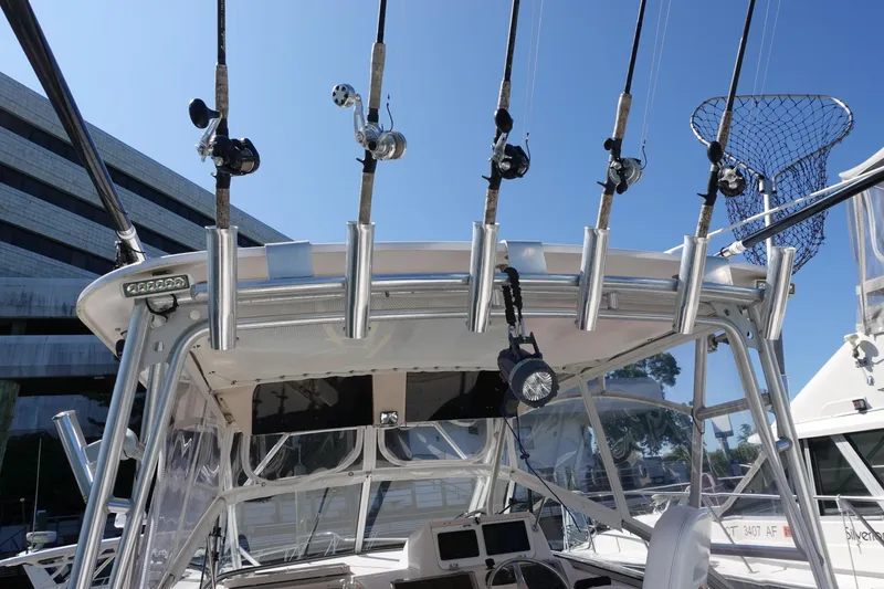 Slide: The Image of Fishing rods on a 2002 Grady White 300 Marlin boat, docked under clear blue sky. - 6