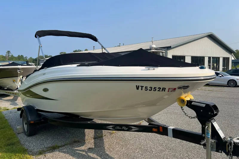 Slide: The Image of 2013 Sea Ray 190 Sport boat on trailer, parked outdoors near a building. - 0