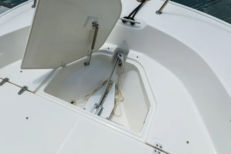 Slide: The Image of Open storage compartment on 2024 Boston Whaler 190 Montauk boat, showing anchor and rope. - 29