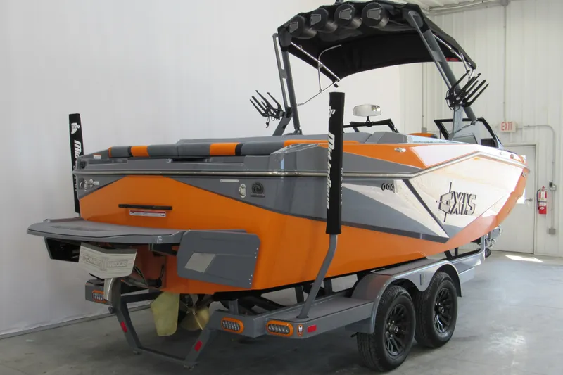 Slide: The Image of 2025 Axis T220 boat in orange and gray, displayed indoors on a trailer. - 3