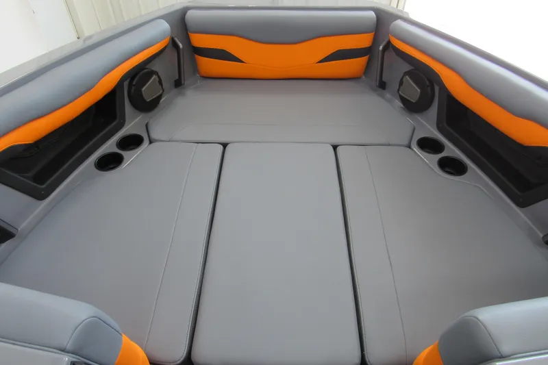 Slide: The Image of 2025 Axis T220 boat interior with gray and orange seating, cup holders, and speakers. - 9