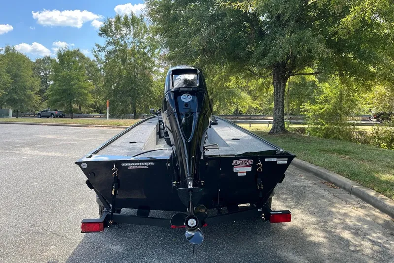 Slide: The Image of 2025 Tracker Panfish 17 boat on trailer, parked outdoors under trees. - 5