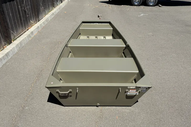 Slide: The Image of 2026 Tracker Grizzly 10 Jon boat on pavement, showcasing its sturdy design and seating arrangement. - 3