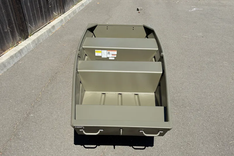 Slide: The Image of 2026 Tracker Grizzly 10 Jon boat on pavement, showcasing interior seating and design. - 4
