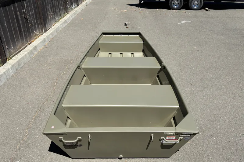 Slide: The Image of 2026 Tracker Grizzly 10 Jon boat on pavement, showcasing its sturdy design and seating arrangement. - 5